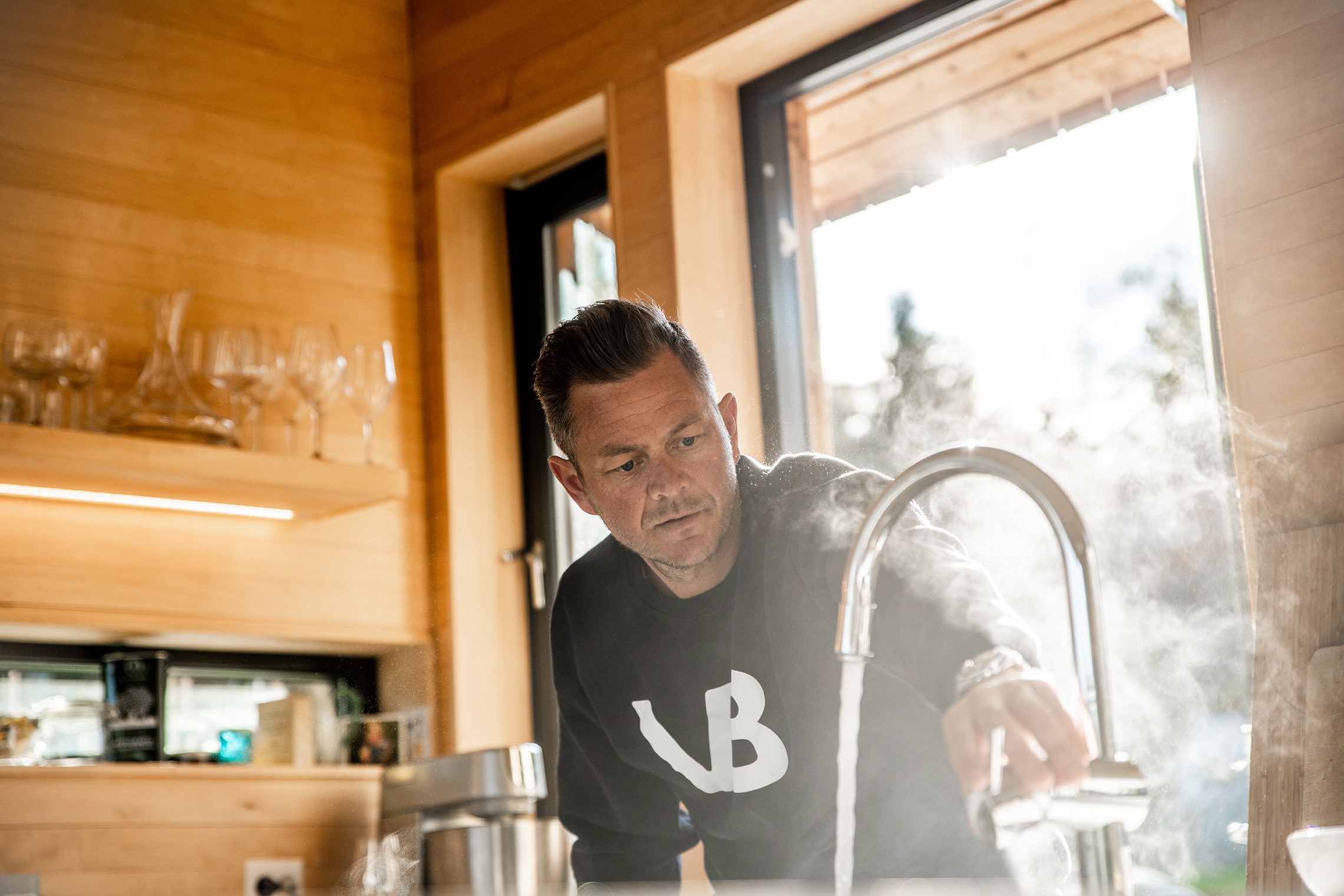 VB-rørlegger tester kjøkkenkran etter montering og vann kommer.